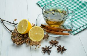 herbal tea with dried herbs spice cinnamon sticks lemon cup wooden tea towel high angle view 176474 6647